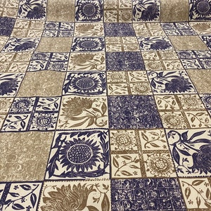 May include: A white fabric with a repeating pattern of brown and blue floral designs. The fabric has a checkered pattern with each square containing a different floral design.