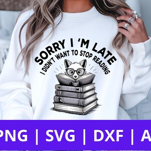 May include: White sweatshirt with the text "SORRY I'M LATE I DIDN'T WANT TO STOP READING". The graphic shows a fox wearing glasses, reading a book atop a stack of books. The bottom of the image has the text "PNG | SVG | DXF | AI".