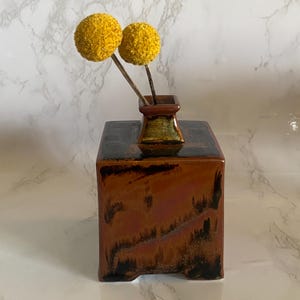Jarrón pequeño de cerámica japonesa vintage, de forma geométrica cuadrada, con esmalte reactivo marrón y firmado.