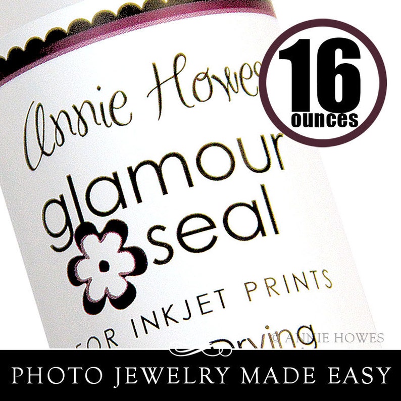 May include: A white bottle with a black and gold label that reads "Annie Howe glamour seal for inkjet prints". The bottle is 16 ounces and features a small flower design. The text "PHOTO JEWELRY MADE EASY" is printed at the bottom of the label.