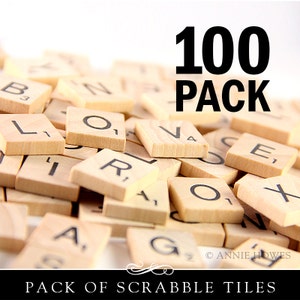 Op de afbeelding: Een close-up van een stapel houten Scrabble-tegels met zichtbare letters. De tegels zijn in willekeurige volgorde gerangschikt. De tekst "100 PACK" is zichtbaar bovenaan de afbeelding. De tekst "PACK OF SCRABBLE TILES" is zichtbaar onderaan de afbeelding.