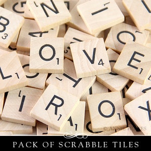 Op de afbeelding: Een close-up afbeelding van een stapel houten Scrabble-tegels. De tegels zijn in willekeurige volgorde gerangschikt en bevatten verschillende letters van het alfabet. De tegels zijn allemaal lichtbruin van kleur en hebben zwarte letters.