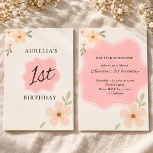 Könnte beinhalten: Zwei rechteckige Geburtstagseinladungskarten mit cremefarbenem Hintergrund, pfirsichfarbenen Blumenillustrationen und rosafarbenen Wellenformen. Die linke Karte zeigt Aurelia's 1st Birthday. Die rechte Karte enthält Veranstaltungsdetails für den 16.01.2027.