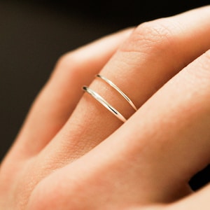 May include: Two thin silver rings worn on a finger.