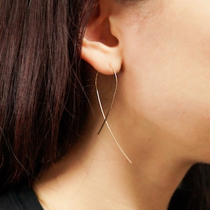 Large Ribbon Hoops that thread through an earlobe piercing and dangle. Modelled in 14K Gold Fill. Thin wire earrings, easy and functional to wear. Shaped like cancer awareness ribbon.