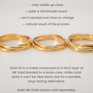Pu&ograve; includere: Tre anelli d'oro impilati uno sopra l'altro. Gli anelli sono in oro 14 carati e presentano un segno di saldatura visibile. Il testo "Nota: Gli anelli in oro pieno e in oro rosa possono presentare un segno di saldatura visibile" &egrave; in alto nell'immagine. Il testo "visibile solo da vicino" &egrave; sotto la prima riga di testo. Il testo "aggiunge un tocco fatto a mano" &egrave; sotto la seconda riga di testo. Il testo "non si diffonder&agrave; nel tempo o cambier&agrave;" &egrave; sotto la terza riga di testo. Il testo "risultato naturale del processo" &egrave; sotto la quarta riga di testo. Il testo "L'oro pieno &egrave; un metallo composto da uno spesso strato di oro 14 carati legato a un nucleo di ottone. A differenza dell'oro massiccio, non pu&ograve; essere limato, ma &egrave; resistente e costituisce un'alternativa durevole." &egrave; sotto gli anelli. Il testo "Versione in oro massiccio 14 carati venduta separatamente." &egrave; sotto la riga di testo precedente. La lettera "N" &egrave; in basso nell'immagine.