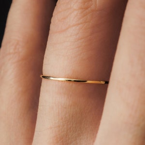 Single Ultra Thin, 0.7mm thick, super skinny stacking ring worn on the Ring Finger. Featuring the 14k Gold Filled version of this ring with a Smooth, polished finish.