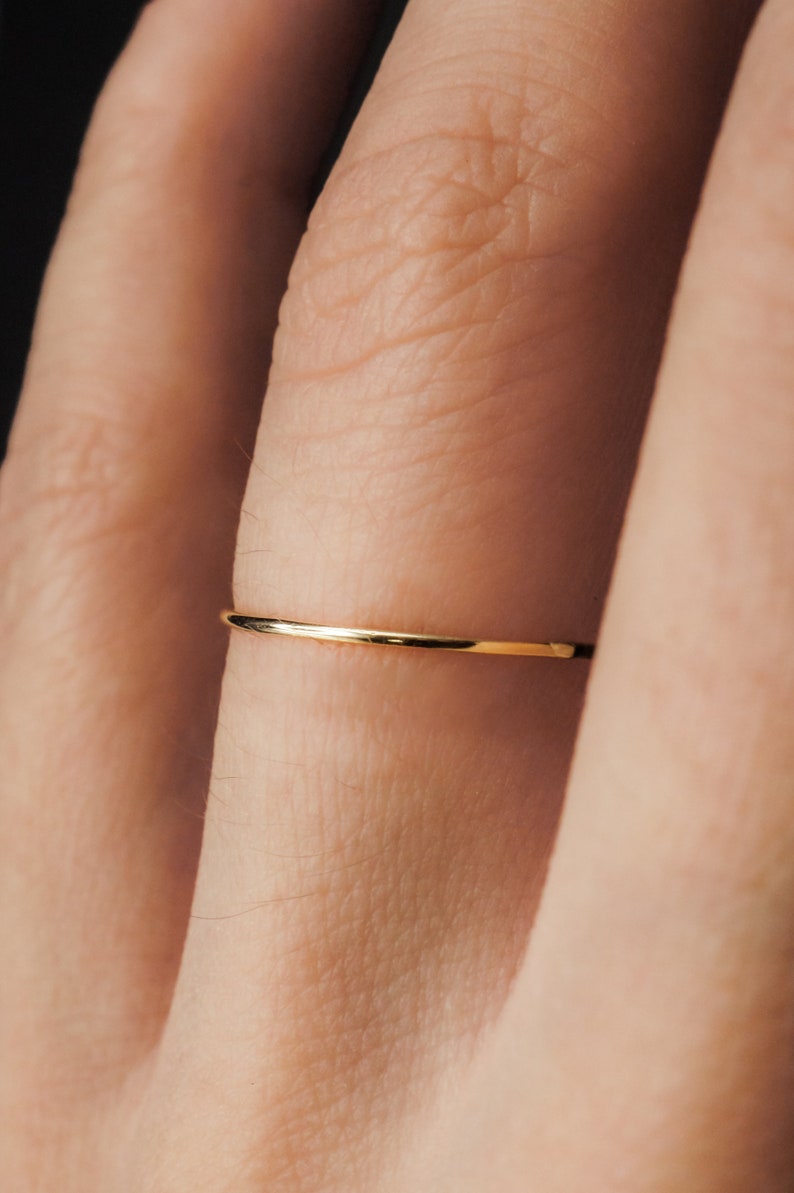 Single Ultra Thin, 0.7mm thick, super skinny stacking ring worn on the Ring Finger. Featuring the 14k Gold Filled version of this ring with a Smooth, polished finish.