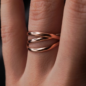 Pu&ograve; includere: Un anello in oro rosa con tre bande intrecciate.