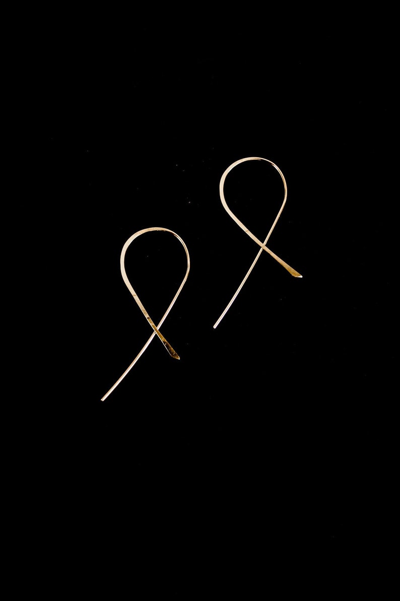 Ribbon Hoops laying flat on black background to show ribbon like shape. Made in 14k Gold Fill.