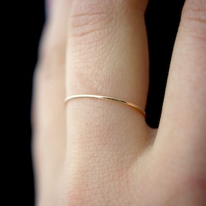 Single Ultra Thin, 0.7mm thick, super skinny stacking ring worn on the Ring Finger. Featuring the 14k Gold Filled version of this ring with a Smooth, polished finish.