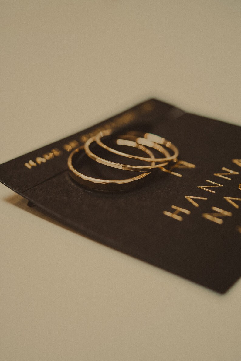 May include: Three gold hammered hoop earrings on a black card with the text "Handmade Jewelry" and "Hanna" in gold lettering.