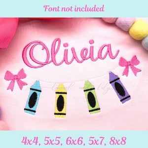 Könnte beinhalten: Rosa besticktes Shirt mit dem Namen "Olivia" in Schreibschrift. Das Design umfasst vier bunte Buntstifte und zwei rosa Schleifen. Der Text "Font not included" steht oben, und die Größen sind unten angegeben.