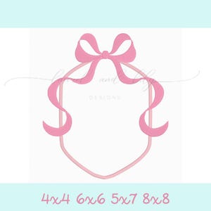 May include: Pink ribbon bow frame with a hexagon shape. The bow is tied at the top of the frame and the ribbon tails extend down the sides of the frame.