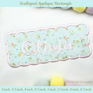 Puede incluir: Un rectángulo de aplique festoneado con el nombre "Olivia" bordado en cursiva. El rectángulo tiene un estampado floral azul claro y un borde festoneado rosa. Disponible en tamaños de 7,6 cm a 16,5 cm.