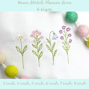 May include: Six embroidery patterns of flowers in different sizes, ranging from 3 to 8 inches. The flowers are white, pink, and purple, and are stitched in a bean stitch style.