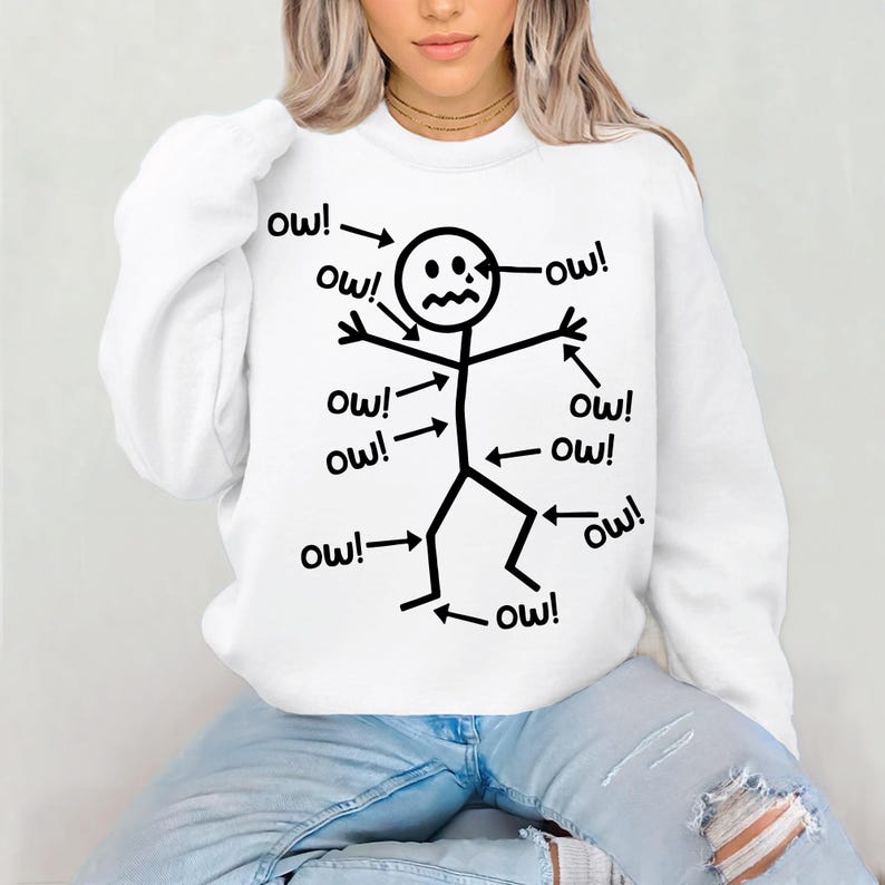 Puede incluir: Sudadera blanca con un dise&ntilde;o de figura de palo negro. La figura de palo tiene la palabra "&iexcl;ay!" apuntando a diferentes partes de su cuerpo, con una expresi&oacute;n angustiada.