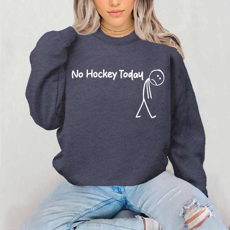 May include: Navy blue sweatshirt with the text "No Hockey Today" and a stick figure with a sad face. The sweatshirt is a crew neck style and is made of a soft material.
