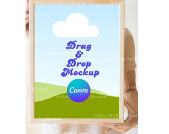May include: A wooden frame with a blue sky, white cloud, and green hills background. The text "Drag & Drop Mockup" is in blue and white. A blue and purple circle with the word "Canva" is in the center of the frame.