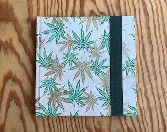 100% Algodão, Caderno de Aquarela de Maconha. 8x8 quadrado, 140 lb., áspero, fecho elástico. Capa dura. Materiais de arquivo sem ácido.