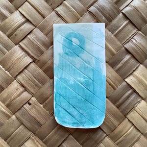 Pu&ograve; includere: Un dipinto ad acquerello blu chiaro su carta con sfondo bianco. Il dipinto presenta un motivo di linee diagonali e un cerchio al centro.