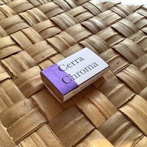 Pu&ograve; includere: Una piccola scatola rettangolare con un'etichetta viola e bianca. L'etichetta riporta "Cerra Chroma" e "Fine iron gall ink".