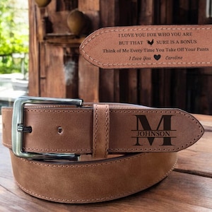 May include: A brown leather belt with a silver buckle. The belt has the initials "M JOHNSON" engraved on the end. The text "I LOVE YOU FOR WHO YOU ARE BUT THAT SURE IS A BONUS Think of Me Every Time You Take Off Your Pants I Love You Caroline" is also engraved.