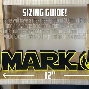 Peut inclure: Une plaque de nom personnalis&eacute;e noire et jaune avec le nom "MARK" et un symbole de l'Alliance rebelle de Star Wars. La plaque mesure 30 cm de long.