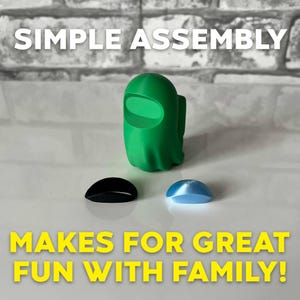 Puede incluir: Una figura verde impresa en 3D con una pieza negra y una pieza azul impresas en 3D. La figura tiene forma de fantasma y el texto "SIMPLE ASSEMBLY MAKES FOR GREAT FUN WITH FAMILY!" est&aacute; impreso debajo de la figura.