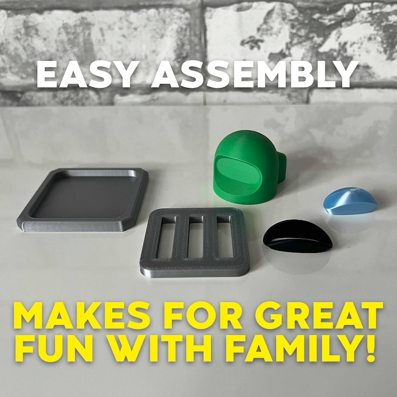 Puede incluir: Un juego de mesa impreso en 3D con un personaje verde, un cuadrado gris, un rect&aacute;ngulo gris con cuatro ranuras, un &oacute;valo negro y un &oacute;valo azul. El texto "EASY ASSEMBLY" est&aacute; en la parte superior de la imagen y el texto "MAKES FOR GREAT FUN WITH FAMILY!" est&aacute; en la parte inferior de la imagen.