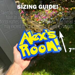 May include: A blue and yellow sign that reads "Alex's Room!" The sign is approximately 17.8 cm tall. The image also includes text that reads "SIZING GUIDE!" and provides sizing information.