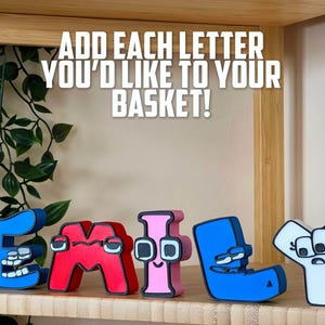 May include: Wooden letters spelling "EMILY" in blue, red, and pink, with cartoon-like faces. The text above reads "ADD EACH LETTER YOU'D LIKE TO YOUR BASKET!" on a wooden shelf.