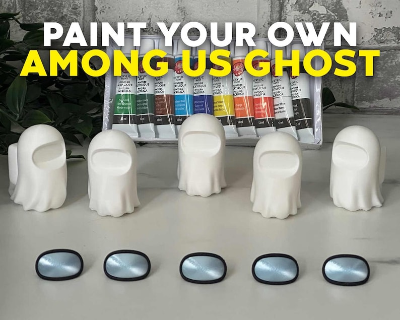 May include: Five white ceramic ghost figurines with black eye holes, ready to be painted. The ghosts are arranged in a row on a gray surface. A set of acrylic paints is visible in the background. The text "PAINT YOUR OWN AMONG US GHOST" is displayed at the top of the image.
