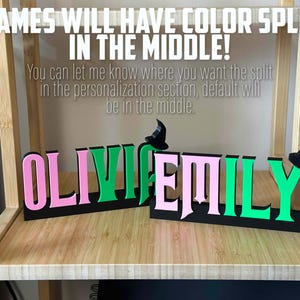 May include: Two names, "Olivia" and "Emily", are displayed in a split color design. The names are in pink and green, with a black background. The names are separated by a small witch's hat.