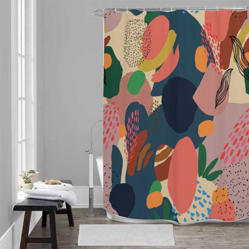 May include: A colorful shower curtain with an abstract design. The pattern features organic shapes in shades of blue, pink, green, orange, and brown against a beige background. The design includes dotted and linear elements.