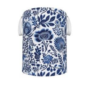 May include: A cylindrical storage container with a white background and a blue floral pattern. The design features various flowers and leaves in shades of blue. White handles are attached to the sides.