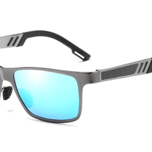 Puede incluir: Gafas de sol modernas con montura de metal gris y lentes azules espejadas. Las patillas son negras y presentan un dise&ntilde;o texturizado. Las gafas tienen forma rectangular.