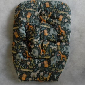 May include: A padded baby seat insert with a dark teal background and a repeating pattern of safari animals in orange, gray, and white. The animals include elephants, giraffes, lions, and zebras.