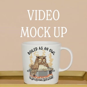 Puede incluir: Taza de cerámica blanca con una ilustración humorística de dos búhos en una olla, con el texto "BOILED AS AN OWL". La taza tiene un asa y está colocada sobre un fondo neutro. Las palabras "VIDEO MOCK UP" están en la parte superior.
