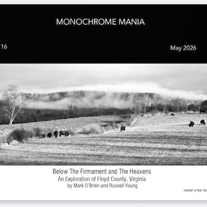 May include: Monochrome Mania magazine cover featuring a black and white landscape photograph of a field with grazing animals and a misty mountain range. The title "Below The Firmament and The Heavens" is displayed, along with the issue number, date, and author information.