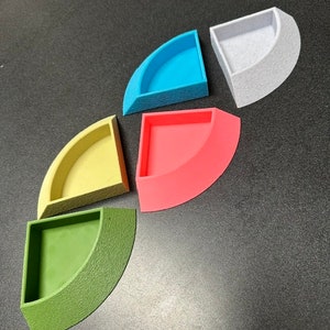 May include: Five quarter circle shaped containers in different colors. The containers are light blue, white, yellow, pink, and green.