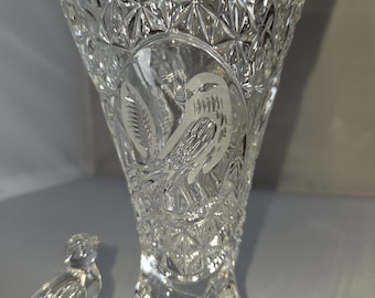 Puede incluir: Un florero de cuerno de la abundancia de vidrio transparente con un patrón de corte de diamante en el cuerpo superior y un diseño grabado esmerilado de un pájaro en una rama. Una pequeña figura de pájaro de vidrio está en la base.