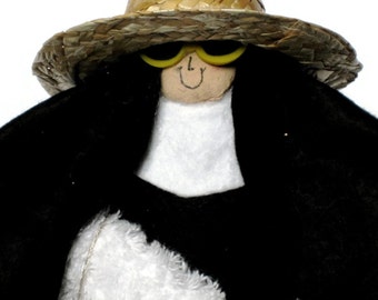 Nun doll beach-loving Sister, wearing sunglasses and sun hat, "Sister Mary Sunshine" the vacationing sister