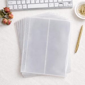 Puede incluir: Una pila de hojas de pl&aacute;stico transparente para archivador con tres bolsillos verticales cada una. Las hojas cuentan con un borde blanco reforzado con agujeros preperforados para encuadernaci&oacute;n de anillas. Fundas para organizar tarjetas.