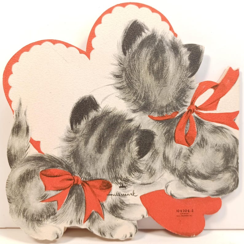 Op de afbeelding: Vintage Valentijnsdagkaart met twee grijze en witte kittens met rode strikken, tegen een hartvormige achtergrond met een geschulpte rode rand. Het Hallmark-logo is zichtbaar.