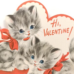 Op de afbeelding: Vintage Valentijnsdagkaart met twee grijze kittens met blauwe ogen en rode strikken. De kaart heeft een hartvormig ontwerp met de woorden "Hi, Valentine!" in rode letters. Een charmante en nostalgische wenskaart.