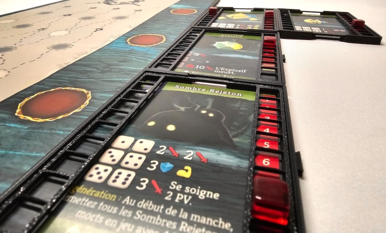 Puede incluir: Un juego de cartas en blanco y negro con una carta de personaje oscuro que muestra una criatura con ojos brillantes. La carta tiene el texto "Sombre Rejeton" y "Se soigne 2 PV". La carta est&aacute; rodeada de un marco negro con dados rojos y blancos.