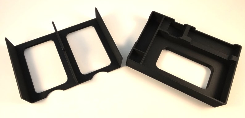 May include: Two black plastic organizers for board games. One organizer has two compartments and the other has multiple compartments.
