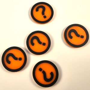 May include: Five orange and black circular game pieces with a question mark on each.