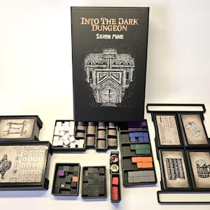 May include: A board game set, "Into The Dark Dungeon Silver Mine", with a black box and various game pieces. The box has a building illustration. Components include cards, tokens, dice, and coin-shaped pieces, all on a white surface.